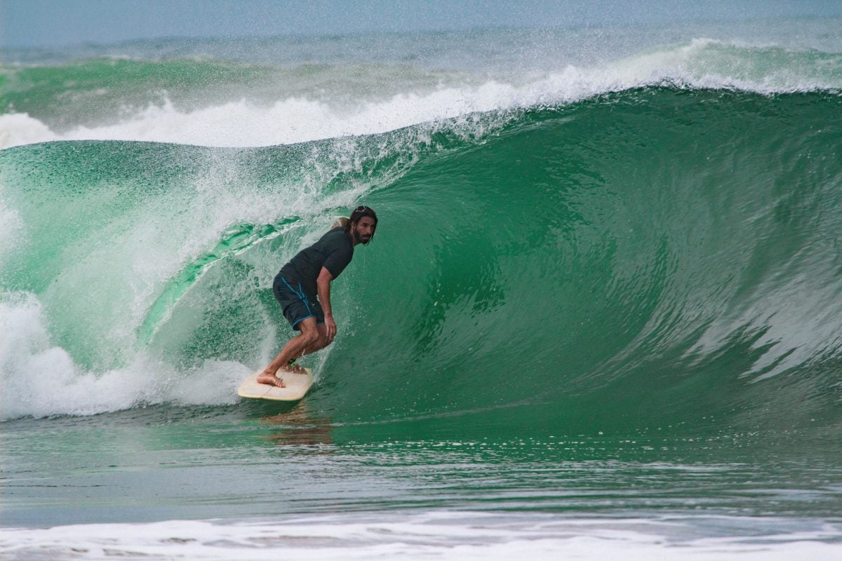 Damien Castera en surf dans un rouleau